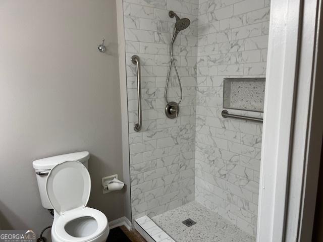 full bathroom with a shower stall and toilet