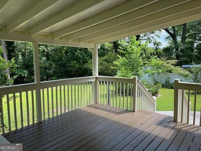 wooden deck featuring a yard and view of wooded area