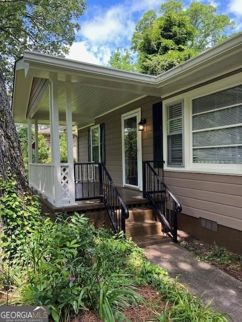 doorway to property with crawl space and a porch