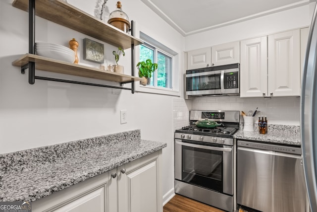 120 Biscayne Dr NW Unit C13, Atlanta, GA 30309 - kitchen featuring appliances with stainless steel finishes, decorative backsplash, white cabinets, and light stone counters
