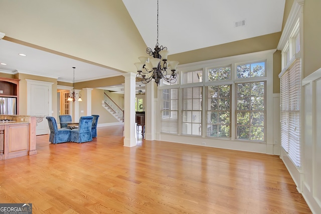 unfurnished dining area with a chandelier, high vaulted ceiling, stairway, light wood-style floors, and recessed lighting