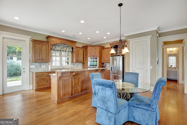 dining room featuring plenty of natural light, light wood finished floors, recessed lighting, ornamental molding, and a chandelier