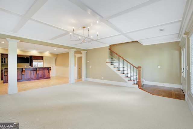 unfurnished living room with ornate columns, stairway, light colored carpet, bar, and coffered ceiling