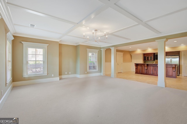 unfurnished living room with ornate columns, coffered ceiling, crown molding, light colored carpet, and a chandelier