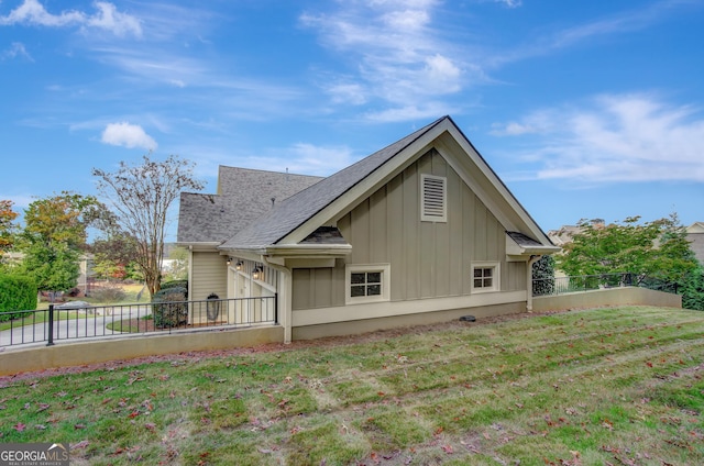 view of side of home featuring board and batten siding and roof with shingles