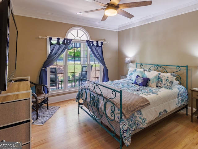bedroom with wood finished floors, crown molding, baseboards, and a ceiling fan
