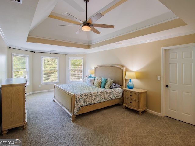 bedroom featuring a raised ceiling, carpet floors, crown molding, baseboards, and a ceiling fan