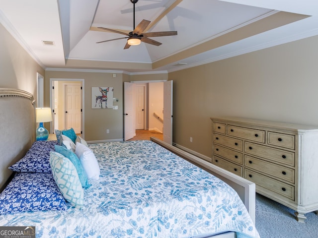 bedroom featuring a raised ceiling, baseboards, ornamental molding, a ceiling fan, and light carpet