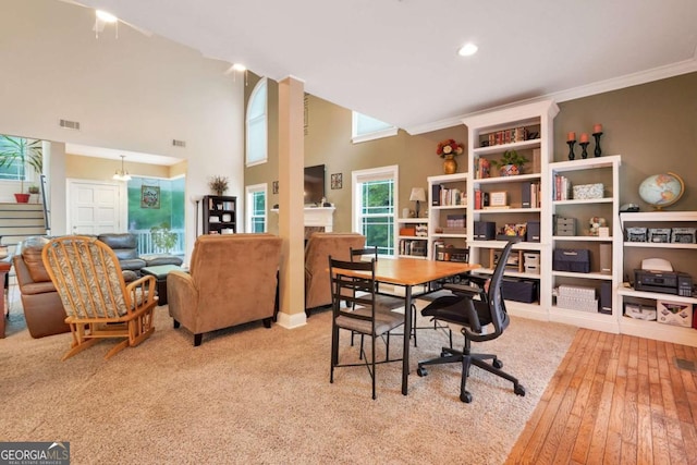office space with crown molding, wood-type flooring, recessed lighting, and a towering ceiling