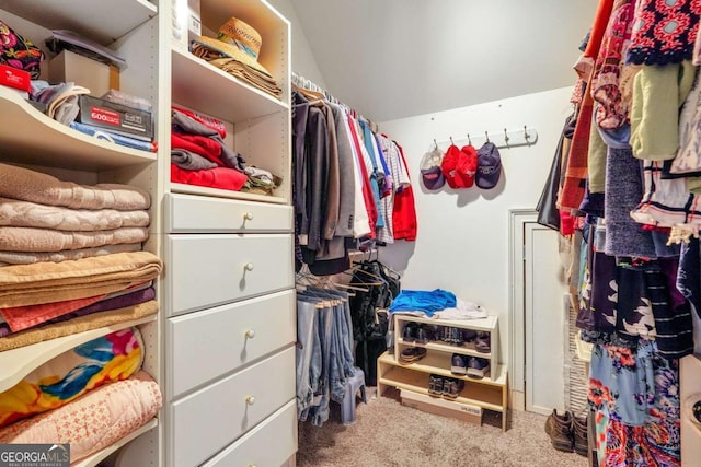 walk in closet with carpet and lofted ceiling