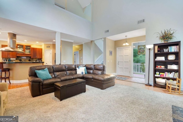 living room featuring wood finished floors, stairs, recessed lighting, and a high ceiling