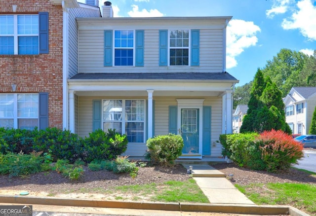10900 Wittenridge Dr Unit L6, Alpharetta, GA 30022 - view of front of house with covered porch, brick siding, and a chimney