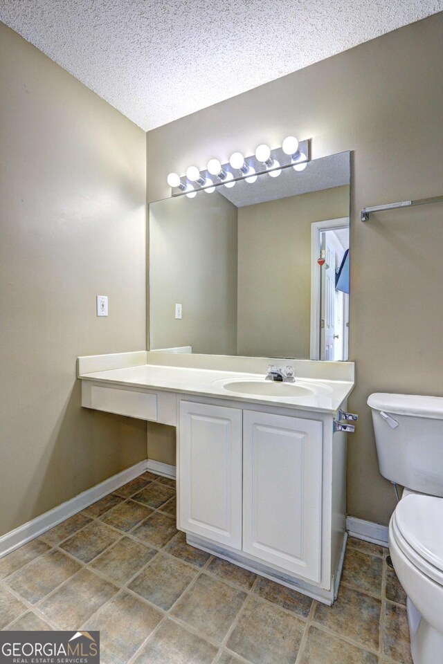 10900 Wittenridge Dr Unit L6, Alpharetta, GA 30022 - bathroom featuring baseboards, toilet, vanity, and a textured ceiling
