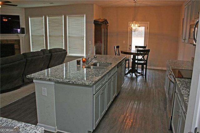 131 Queens Cemetery Rd, Good Hope, GA 30641 - kitchen with a sink, open floor plan, dark wood finished floors, a stone fireplace, and light stone counters