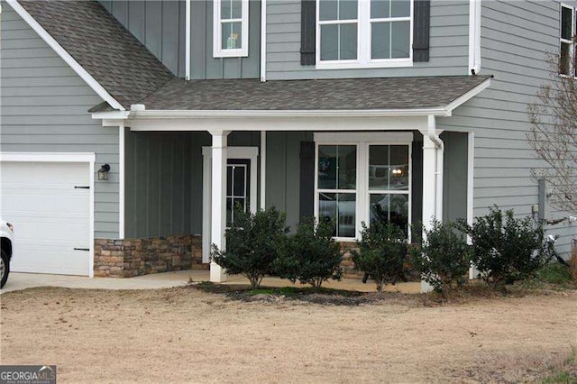 131 Queens Cemetery Rd, Good Hope, GA 30641 - property entrance with board and batten siding, a shingled roof, covered porch, and an attached garage