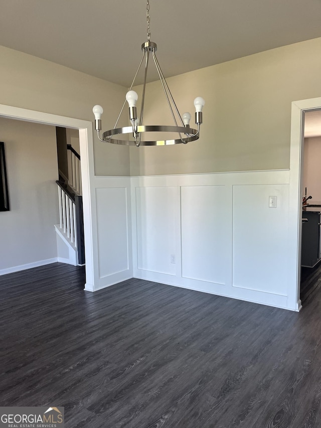 131 Queens Cemetery Rd, Good Hope, GA 30641 - unfurnished dining area with a chandelier, a decorative wall, dark wood-style floors, wainscoting, and stairway