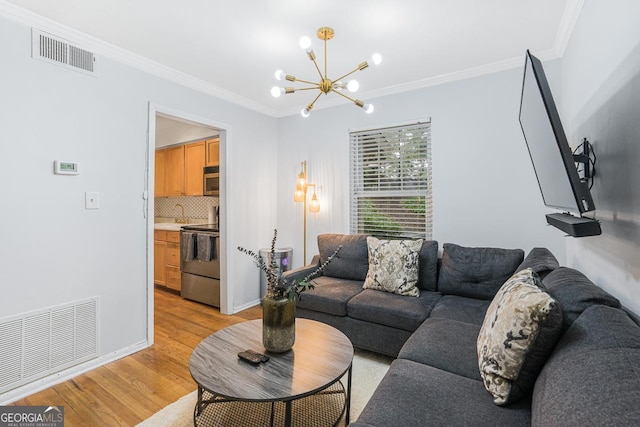 1150 Collier Rd NW Unit 25D, Atlanta, GA 30318 - living room featuring a chandelier, light wood finished floors, crown molding, and baseboards