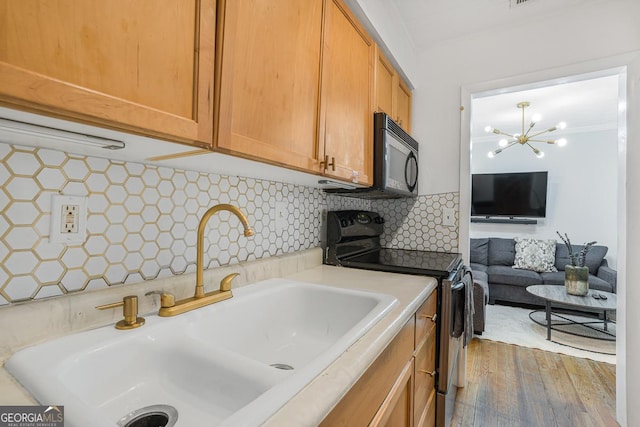1150 Collier Rd NW Unit 25D, Atlanta, GA 30318 - kitchen featuring electric stove, black microwave, a sink, light countertops, and decorative backsplash