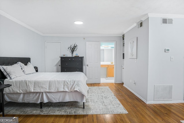 1150 Collier Rd NW Unit 25D, Atlanta, GA 30318 - bedroom with wood finished floors, baseboards, crown molding, and connected bathroom