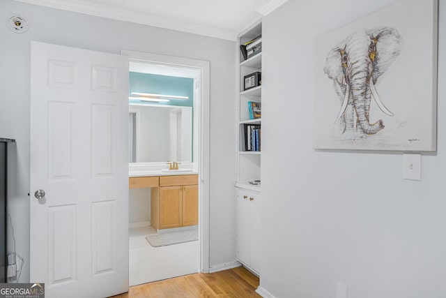 1150 Collier Rd NW Unit 25D, Atlanta, GA 30318 - hallway with light wood-style flooring, ornamental molding, built in features, and a sink