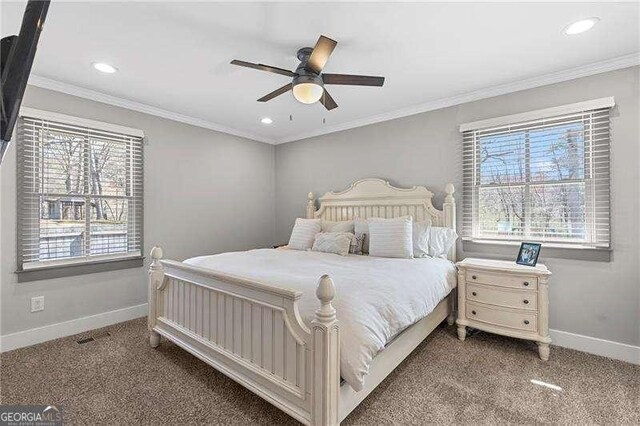 carpeted bedroom with multiple windows, baseboards, recessed lighting, ceiling fan, and crown molding