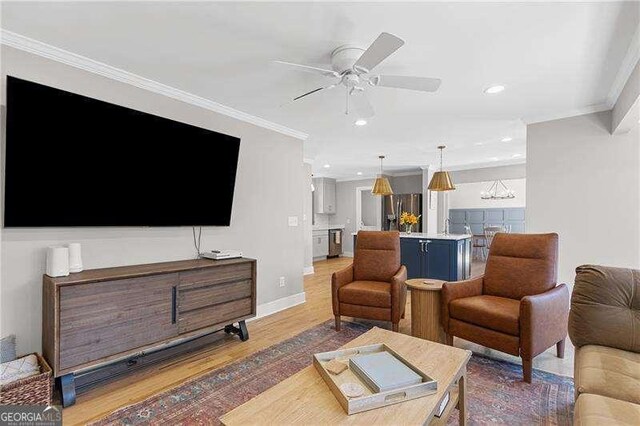 living room with crown molding, wood finished floors, a ceiling fan, recessed lighting, and baseboards