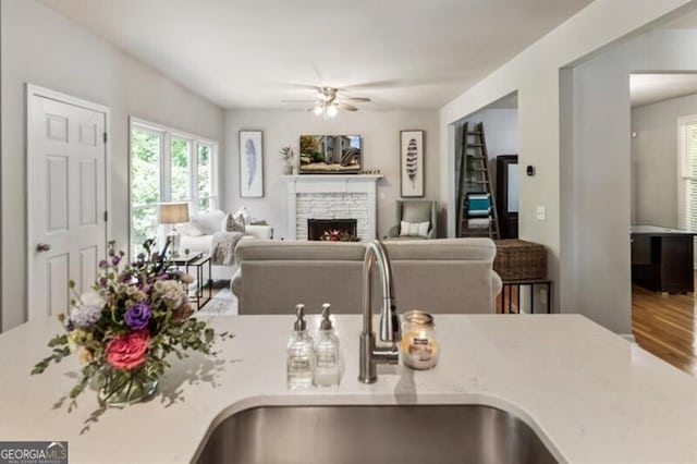 143 Treadstone Ln, Dallas, GA 30132 - kitchen with ceiling fan, light countertops, a stone fireplace, wood finished floors, and open floor plan
