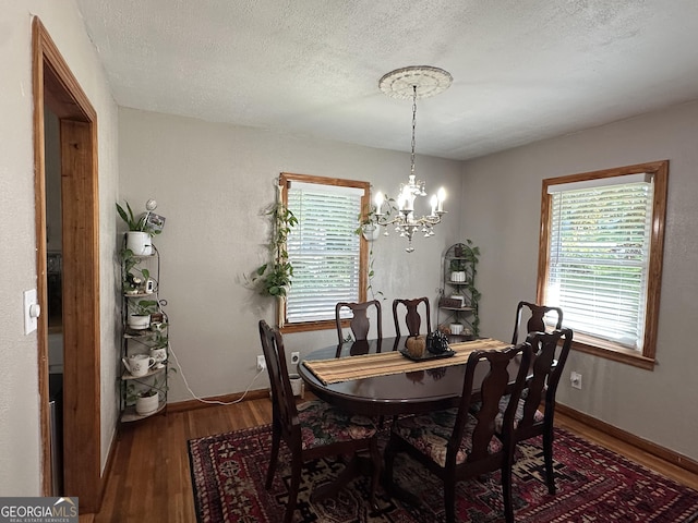 2059 Clearwater Dr SE, Marietta, GA 30067 - dining room featuring wood finished floors, a chandelier, healthy amount of natural light, a textured ceiling, and baseboards