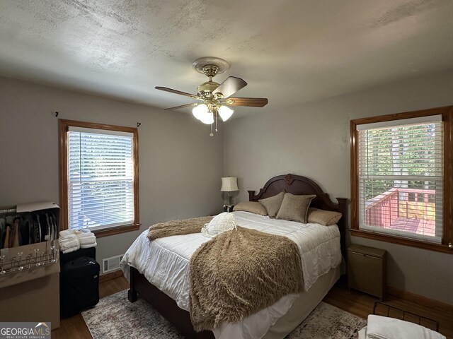 2059 Clearwater Dr SE, Marietta, GA 30067 - bedroom with multiple windows, wood finished floors, baseboards, and a ceiling fan
