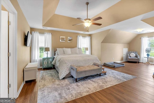 3477 Seneca Farm Dr, Buford, GA 30519 - bedroom with wood finished floors, a tray ceiling, baseboards, and ceiling fan
