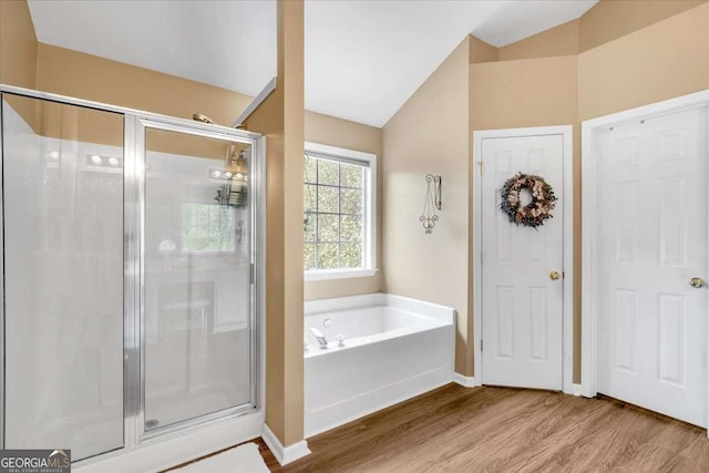 3477 Seneca Farm Dr, Buford, GA 30519 - full bathroom featuring vaulted ceiling, wood finished floors, a garden tub, a stall shower, and baseboards