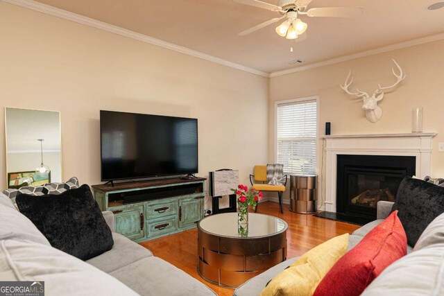 5888 Cobblestone Creek Cir, Mableton, GA 30126 - living area with wood finished floors, crown molding, a ceiling fan, and a glass covered fireplace