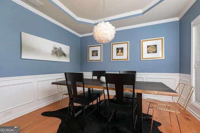 5888 Cobblestone Creek Cir, Mableton, GA 30126 - dining space featuring wood finished floors, a chandelier, a raised ceiling, wainscoting, and a decorative wall
