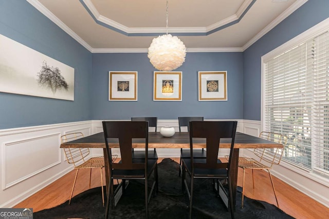 5888 Cobblestone Creek Cir, Mableton, GA 30126 - dining space with wood finished floors, a tray ceiling, a chandelier, ornamental molding, and wainscoting