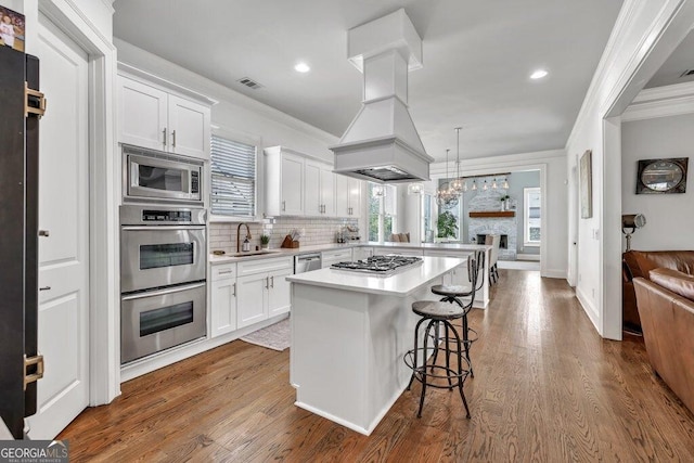 5461 Autumn Flame Dr, Braselton, GA 30517 - kitchen with a sink, stainless steel appliances, ornamental molding, light countertops, and a kitchen breakfast bar