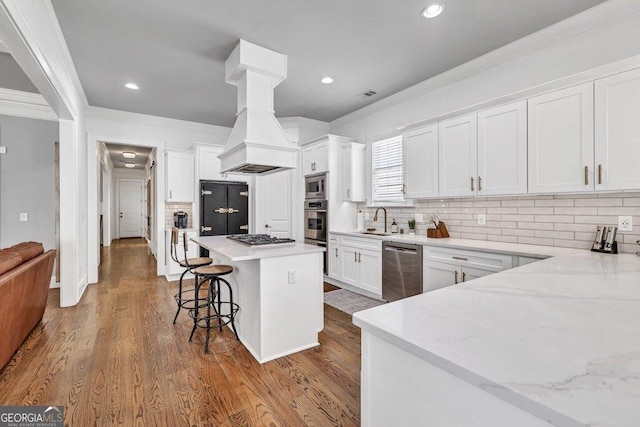 5461 Autumn Flame Dr, Braselton, GA 30517 - kitchen featuring stainless steel appliances, a sink, ornamental molding, white cabinetry, and a breakfast bar