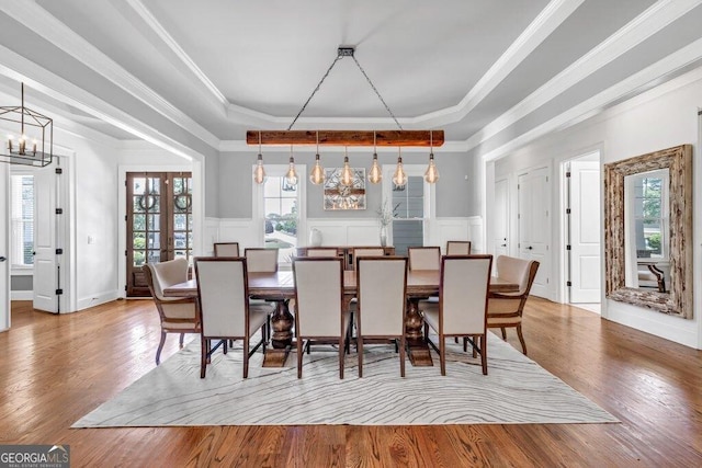 5461 Autumn Flame Dr, Braselton, GA 30517 - dining space with a chandelier, a tray ceiling, wood finished floors, a decorative wall, and wainscoting