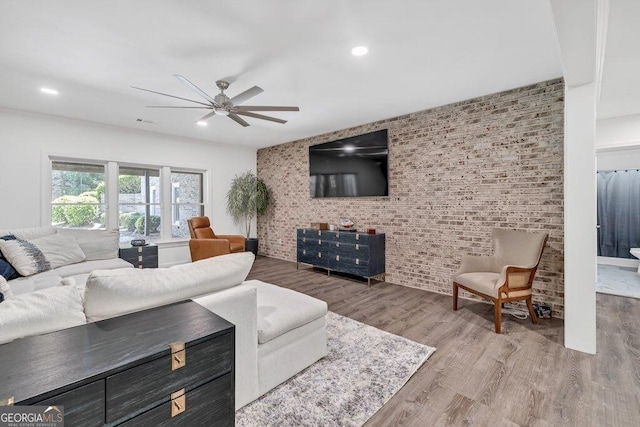 5461 Autumn Flame Dr, Braselton, GA 30517 - living area featuring ceiling fan, wood finished floors, brick wall, and an accent wall