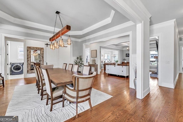 5461 Autumn Flame Dr, Braselton, GA 30517 - dining space with washer / clothes dryer, wood finished floors, a chandelier, a tray ceiling, and crown molding
