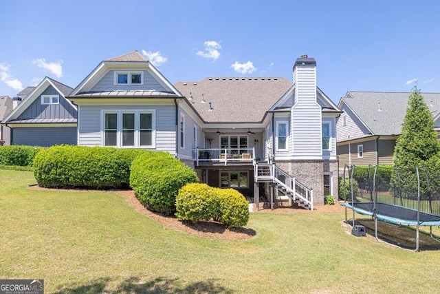 5461 Autumn Flame Dr, Braselton, GA 30517 - back of house featuring a trampoline, stairway, a lawn, a standing seam roof, and ceiling fan