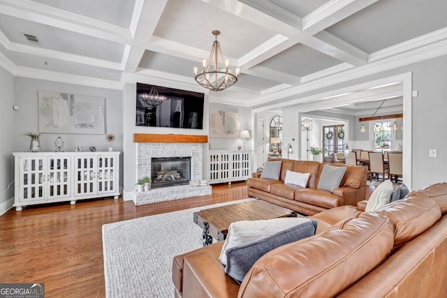 5461 Autumn Flame Dr, Braselton, GA 30517 - living area with a chandelier, coffered ceiling, ornamental molding, beamed ceiling, and wood finished floors
