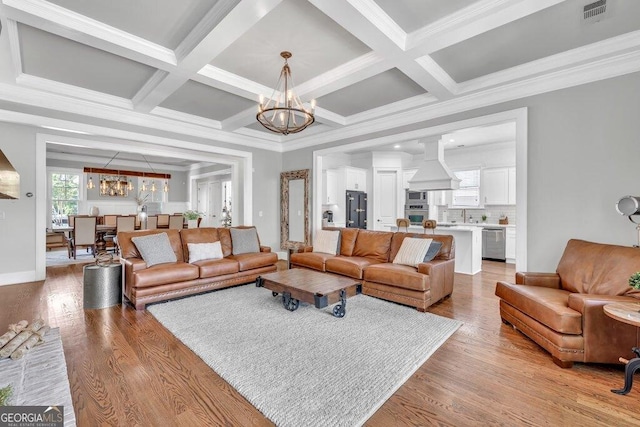 5461 Autumn Flame Dr, Braselton, GA 30517 - living room featuring a chandelier, light wood-style flooring, beam ceiling, coffered ceiling, and crown molding