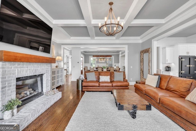 5461 Autumn Flame Dr, Braselton, GA 30517 - living area featuring a chandelier, ornamental molding, dark wood-type flooring, a fireplace, and beam ceiling