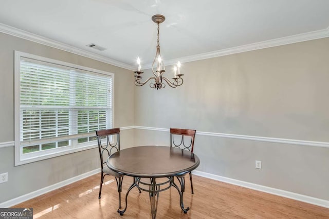 dining area with a chandelier, wood finished floors, baseboards, and ornamental molding