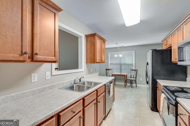kitchen with a sink, appliances with stainless steel finishes, light countertops, baseboards, and brown cabinetry