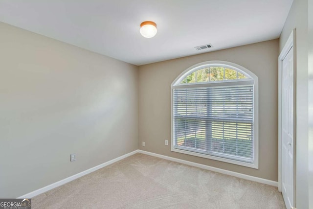 carpeted empty room featuring baseboards
