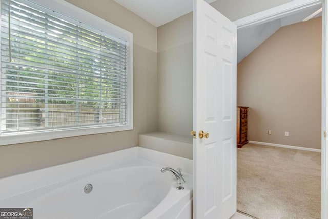 bathroom with a garden tub and lofted ceiling