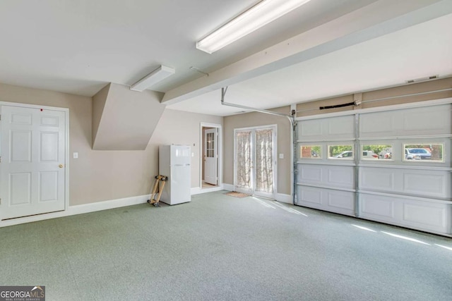 garage with freestanding refrigerator and baseboards