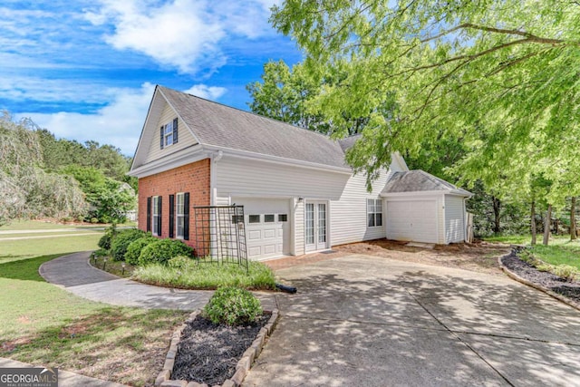 view of home's exterior with brick siding, an attached garage, driveway, and a shingled roof