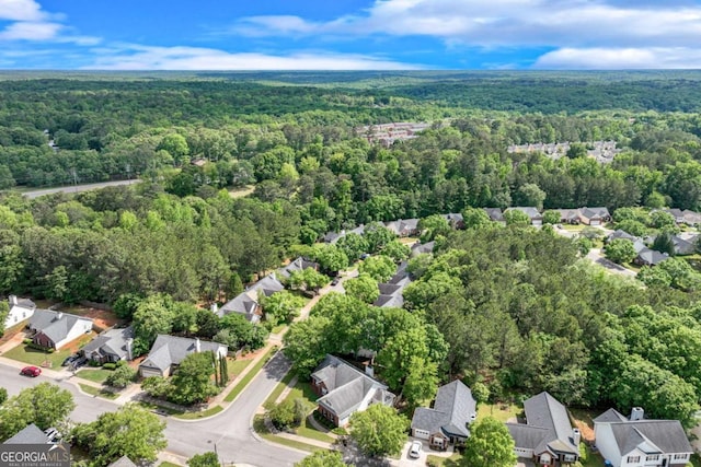 view of property location with a forest and nearby suburban area